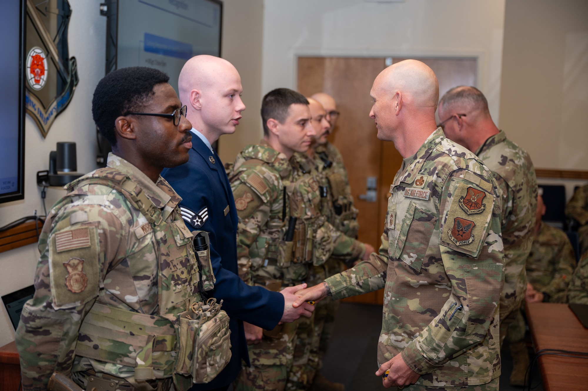 Chief Master Sgt. Andrew Rapsavage, 377th Air Base Wing command chief, presents a coin to Senior Airman Seth Fenton during a recognition ceremony at Kirtland Air Force Base, N.M., April 14. The Airmen were honored for their swift response to a bomb threat that occurred March 22 at the Eubank Gate, demonstrating vigilance, rapid coordination and commitment to installation security. (U.S. Air Force photo by Senior Airman Donnell Schroeter)