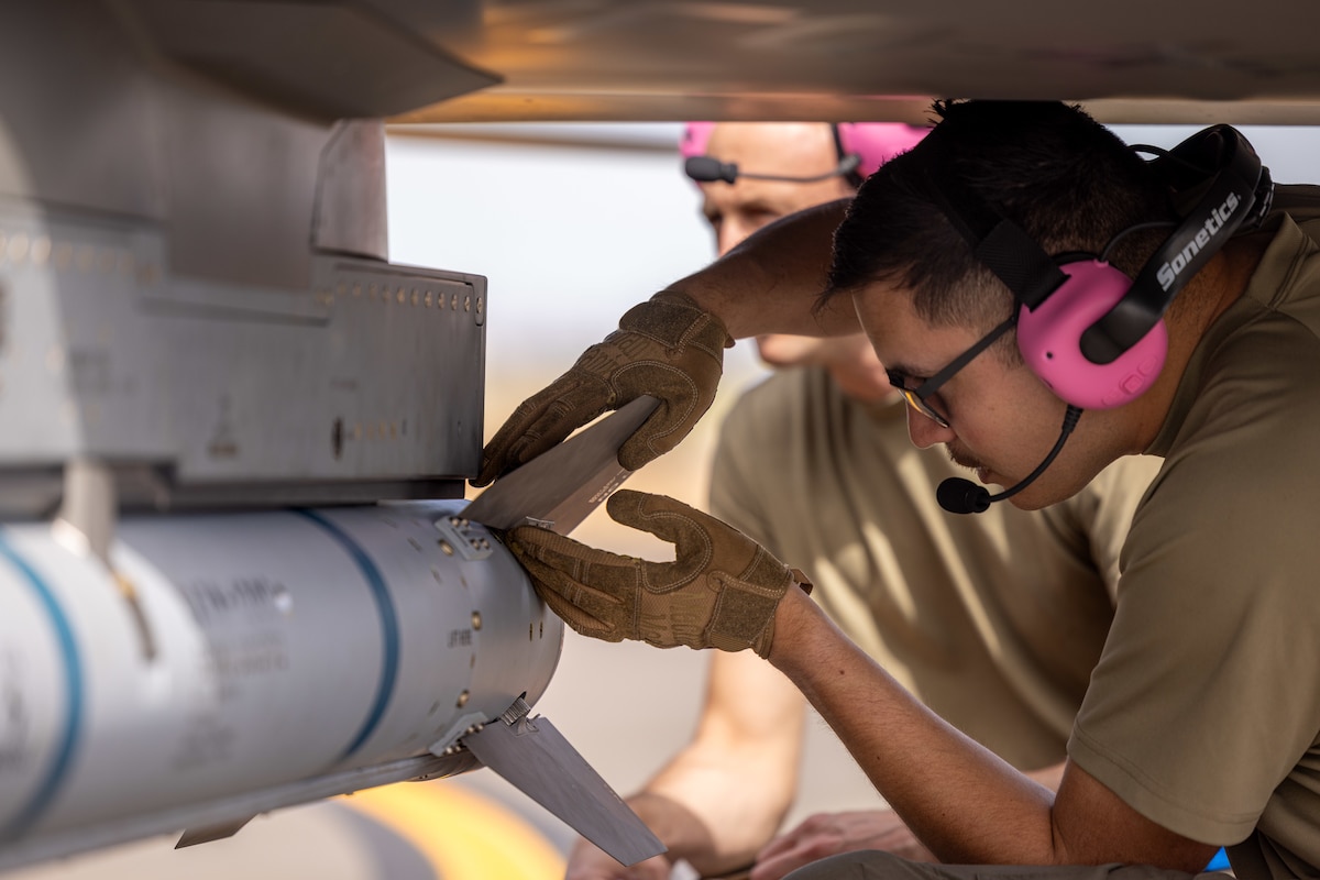 U.S. Air Force Master Sgt. Ricardo Villalva Jr. with Air Combat Command’s Experimental Operations Unit, performs pre-flight checks on an inert munition at Edwards Air Force Base, Calif. The unit enables operators to develop tactics that ensure Collaborative Combat Aircraft are viable for future operations. (U.S. Air Force photo by Ariana Ortega)