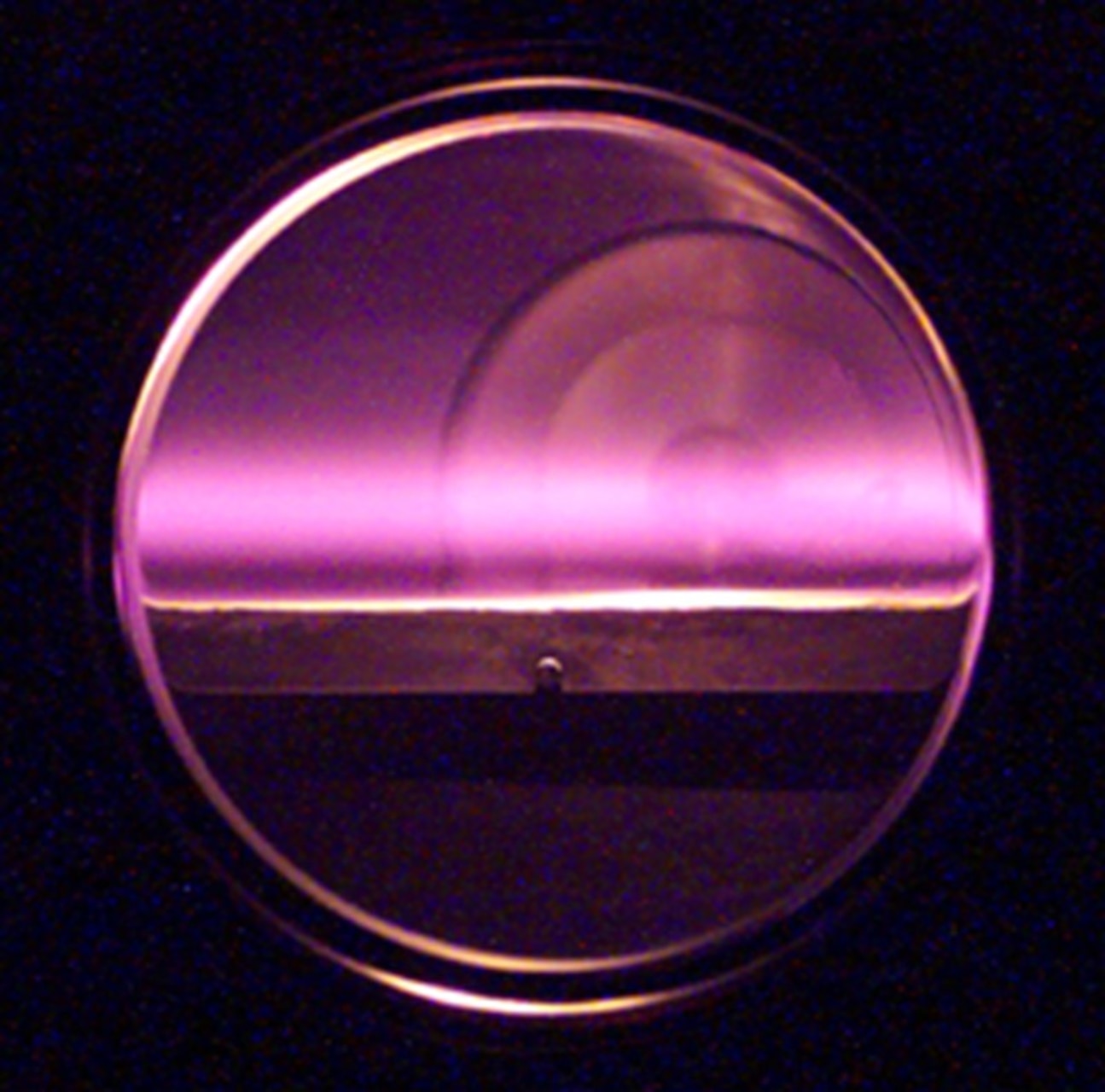 A glowing plasma inside the Large Area Plasma Processing System (LAPPS). The U.S. Naval Research Laboratory-developed LAPPS facility enables material processing with atomic-layer precision and supports the development of advanced materials for the Navy. (U.S. Navy photo)