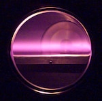 A glowing plasma inside the Large Area Plasma Processing System (LAPPS). The U.S. Naval Research Laboratory-developed LAPPS facility enables material processing with atomic-layer precision and supports the development of advanced materials for the Navy. (U.S. Navy photo)