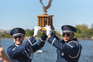 Senior Airmen Aaron Miles, left, and Wijeury Collado, right, U.S. Air Force Honor Guard ceremonial guardsmen, hold the Joint Service Drill Exhibition trophy at the Jefferson Memorial in Washington, D.C., April 11, 2026. Military drill teams from all U.S. military services performed while being evaluated on factors such as military bearing, precision, and crowd interaction. The U.S. Air Force Honor Guard Drill Team won the annual exhibition for the first time in 14 years. (U.S. Air Force courtesy photo)