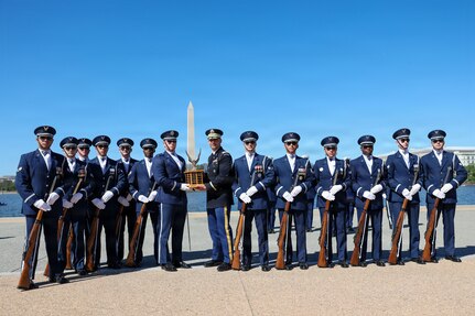 The U.S. Air Force Honor Guard Drill Team poses with the ceremonial trophy after winning the Joint Service Drill Exhibition at the Jefferson Memorial, Washington, D.C., April 11, 2026. Military drill teams from all U.S. military services performed while being evaluated on factors such as military bearing, precision, and crowd interaction. The U.S. Air Force Honor Guard Drill Team won the annual exhibition for the first time in 14 years. (U.S. Marine Corps photo by Cpl. Christopher Prelle)