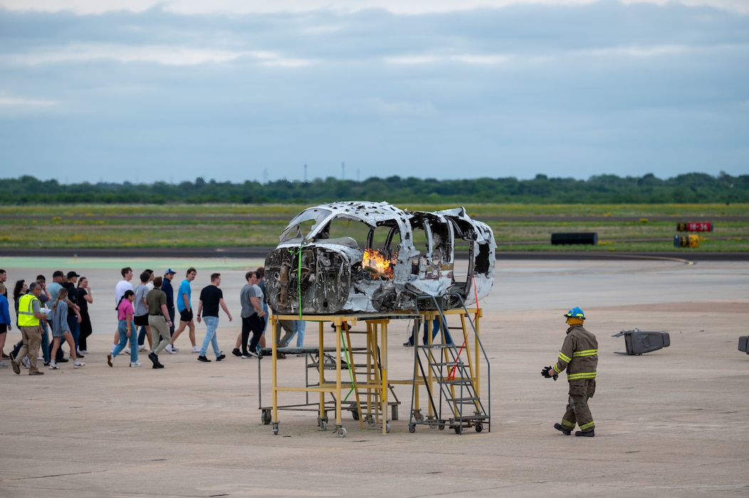 Participants observe a simulated aircraft fire following a notional plane crash during a joint emergency response exercise at Mathis Field, San Angelo Regional Airport, San Angelo, Texas, April 15, 2026. The fire was intentionally ignited as part of the training scenario to replicate real-world emergency conditions. (U.S. Air Force photo by Senior Airman James Salellas)