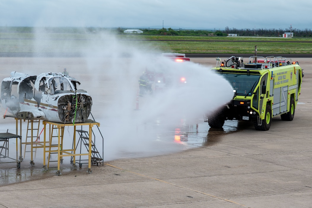 Firefighters apply water to a simulated aircraft fire during a joint emergency response exercise at Mathis Field, San Angelo Regional Airport, San Angelo, Texas, April 15, 2026.  The scenario tested emergency response capabilities under realistic conditions. (U.S. Air Force photo by Senior Airman James Salellas)
