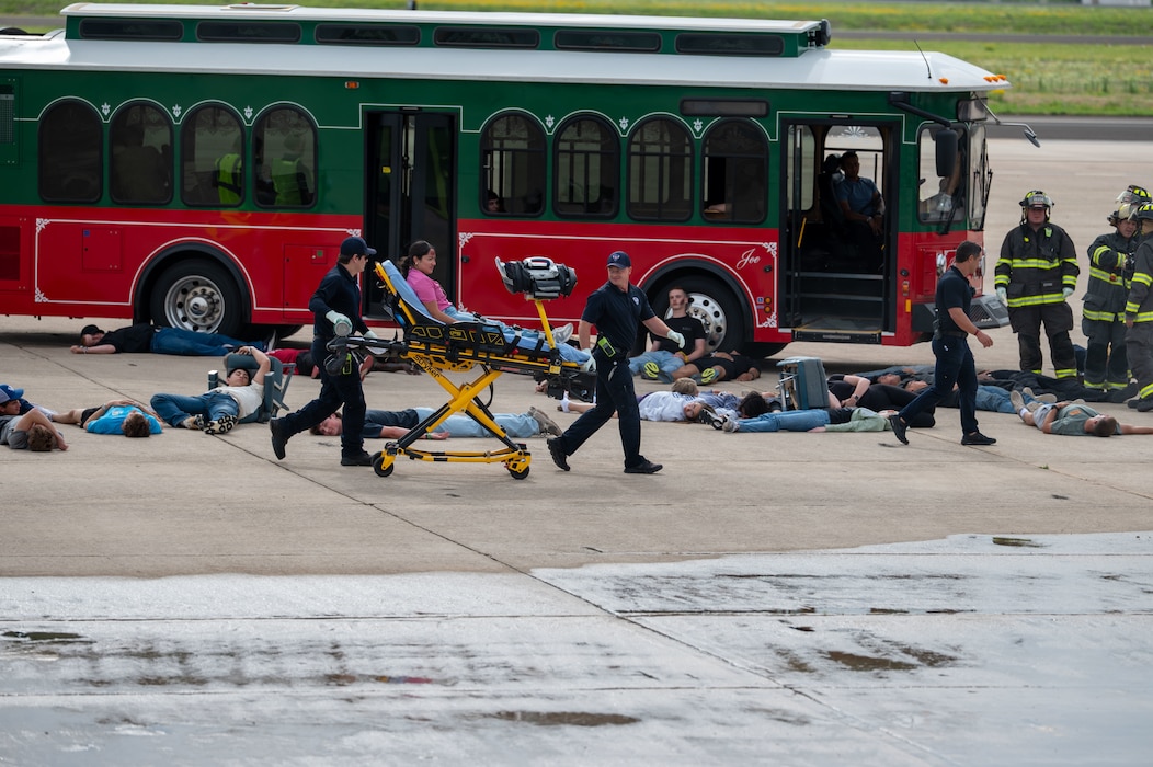 Emergency medical personnel transport a simulated casualty on a stretcher during a joint emergency response exercise at Mathis Field, San Angelo Regional Airport, San Angelo, Texas, April 15, 2026. Volunteers acted as victims to support a mass casualty scenario designed to improve interagency response and coordination. (U.S. Air Force photo by Senior Airman James Salellas)