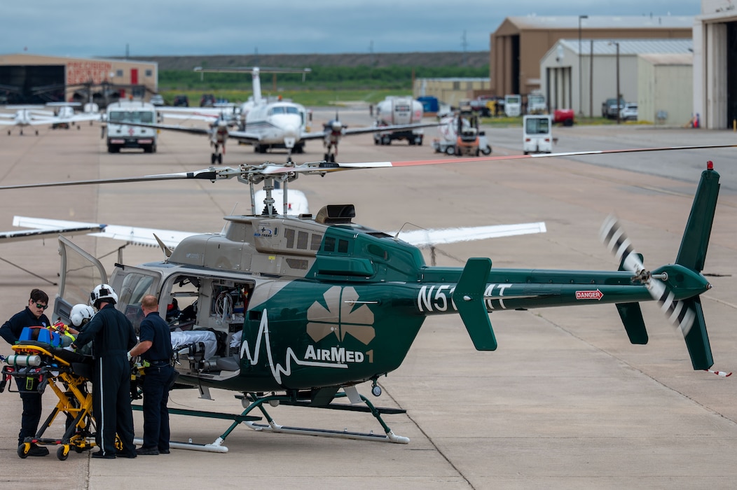 Emergency medical personnel load a simulated casualty into an AirMed helicopter during a joint emergency response exercise at Mathis Field, San Angelo Regional Airport, San Angelo, Texas, April 15, 2026. The exercise tested medical evacuation procedures and interagency communication. (U.S. Air Force photo by Senior Airman James Salellas)