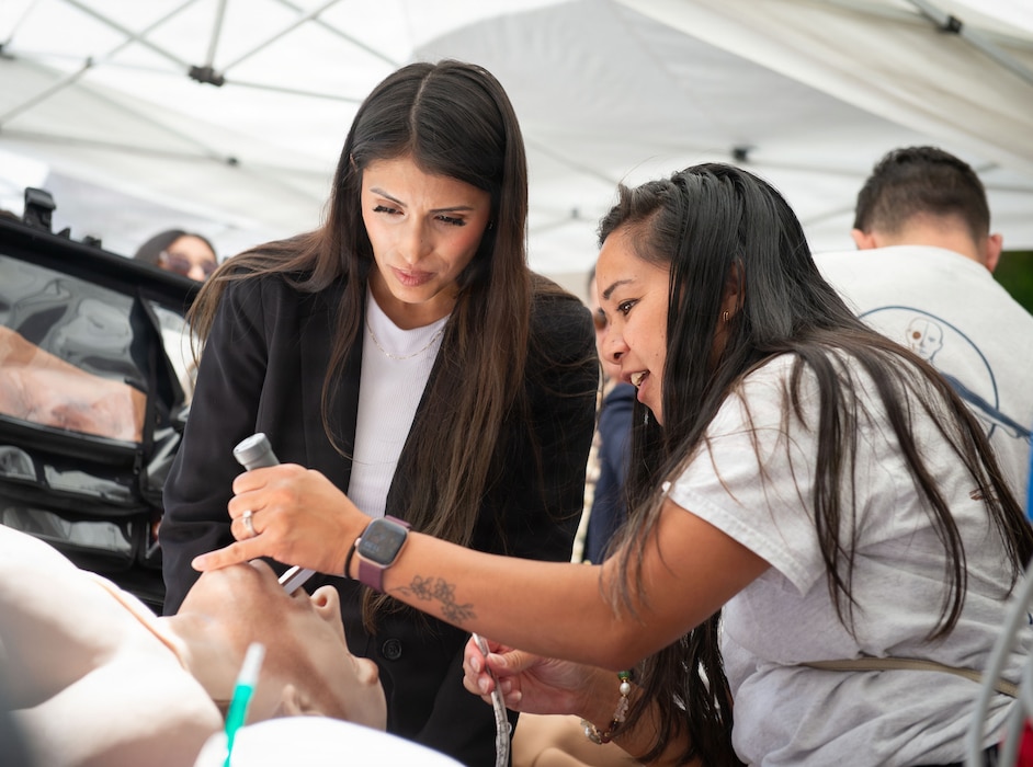 Myra Saldana, right, a nurse educator at Naval Medical Center San Diego, shows Nina Mendoza, a student at Alliant University, how to insert a laryngoscope on an interactive patient simulator during the 41st Academic Research Competition at NMCSD, April 10. NMCSD employs more than 5,500 active-duty military personnel, civilians, and contractors in Southern California to deliver exceptional care afloat and ashore. (U.S. Navy photo by Mass Communication Specialist 1st Class Marcus L. Stanley)