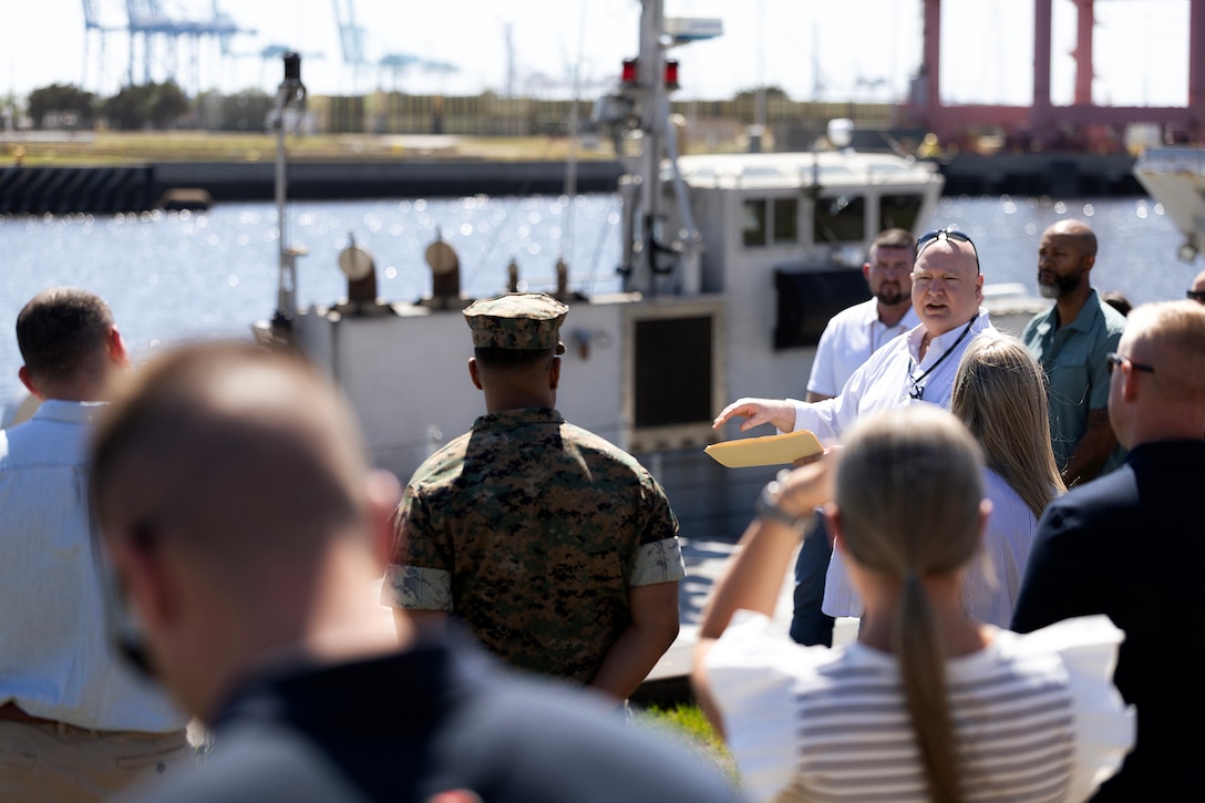 William Fish, Navy prepositioning department director at Blount Island Command, explains the Improved Navy Lighterage System along a slipway April 15 at Marine Corps Support Facility Blount Island, Florida. Dozens of senior leaders from 2nd Marine Logistics Group participated in a conference hosted by Marine Corps Logistics Command, focused on strengthening a shared understanding of mission, structure, capabilities and innovation efforts, while building relationships to enhance warfighter support. (U.S. Marine Corps photo by Dustin Senger)