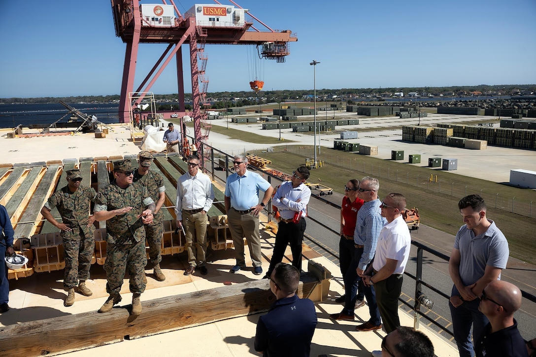 U.S. Marine Corps Chief Warrant Officer 3 Alexander Woodward, port operations officer in charge at Blount Island Command, explains cargo loading procedures aboard the USNS Sgt. William R. Button, berthed along the slipway April 15 at Marine Corps Support Facility Blount Island, Florida. Dozens of senior leaders from 2nd Marine Logistics Group participated in a conference hosted by Marine Corps Logistics Command, focused on strengthening a shared understanding of mission, structure, capabilities and innovation efforts, while building relationships to enhance warfighter support. (U.S. Marine Corps photo by Dustin Senger)
