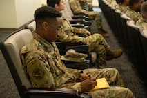 An Airmen taking notes during the MTI roadshow briefing.