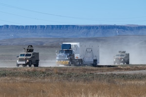 A convoy driving through a gravel road.