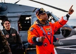 NASA astronaut Victor Glover points at crew members on the flight deck of the San Antonio Class amphibious transport dock USS John P. Murtha (LPD 26) after returning from space on Apr. 10, 2026.