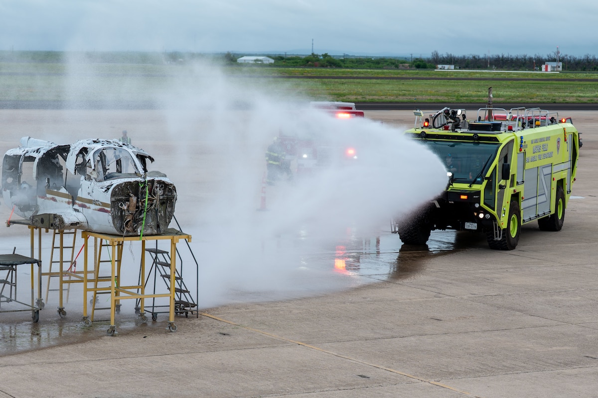 Firefighters apply water to a simulated aircraft fire during a joint emergency response exercise at Mathis Field, San Angelo Regional Airport, San Angelo, Texas, April 15, 2026.  The scenario tested emergency response capabilities under realistic conditions. (U.S. Air Force photo by Senior Airman James Salellas)