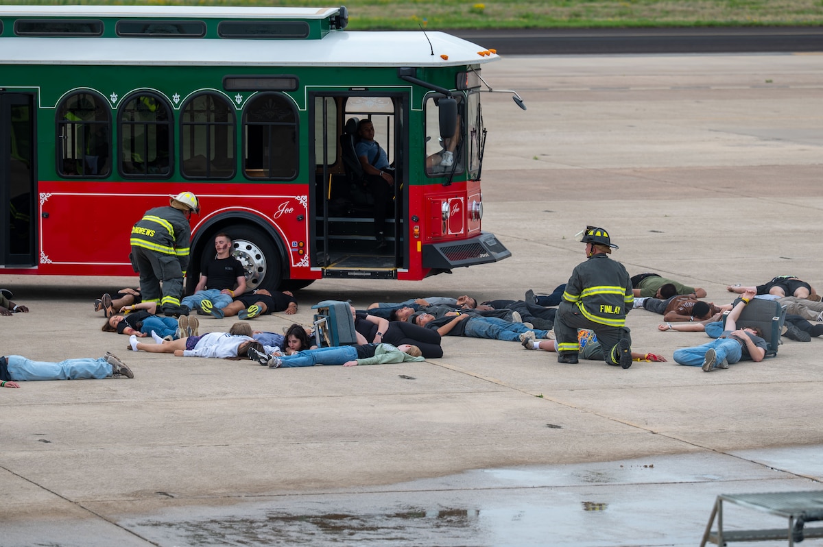 Emergency responders assess simulated casualties near a bus during a joint emergency response exercise at Mathis Field, San Angelo Regional Airport, San Angelo, Texas, April 15, 2026. The exercise focused on improving response times and coordination between agencies. (U.S. Air Force photo by Senior Airman James Salellas)