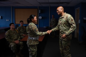U.S. Air Force Maj. Gen. Roy W. Collins, Air Education Training Command deputy commander, coins Airmen student leaders inside the 316th Training Squadron dorms at Goodfellow Air Force Base, Texas, April 10, 2026. The 316th TRS is tasked with training, developing and inspiring the next generation of intelligence, surveillance and reconnaissance warriors. (U.S. Air Force photo by Senior Airman Brian Lummus)