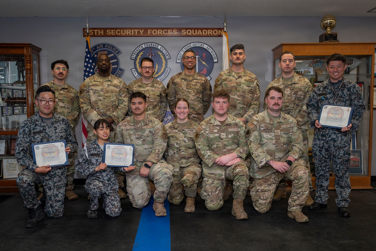 U.S. Air Force Military Working Dog handlers assigned to the 35th Security Forces Squadron and Japan Air Self-Defense Force security forces K-9 handlers assigned to the 3rd and 4th Air Wings pose for a group photo at the end of a joint bilateral K-9 exercise at Misawa Air Base, Japan, April 10, 2026.