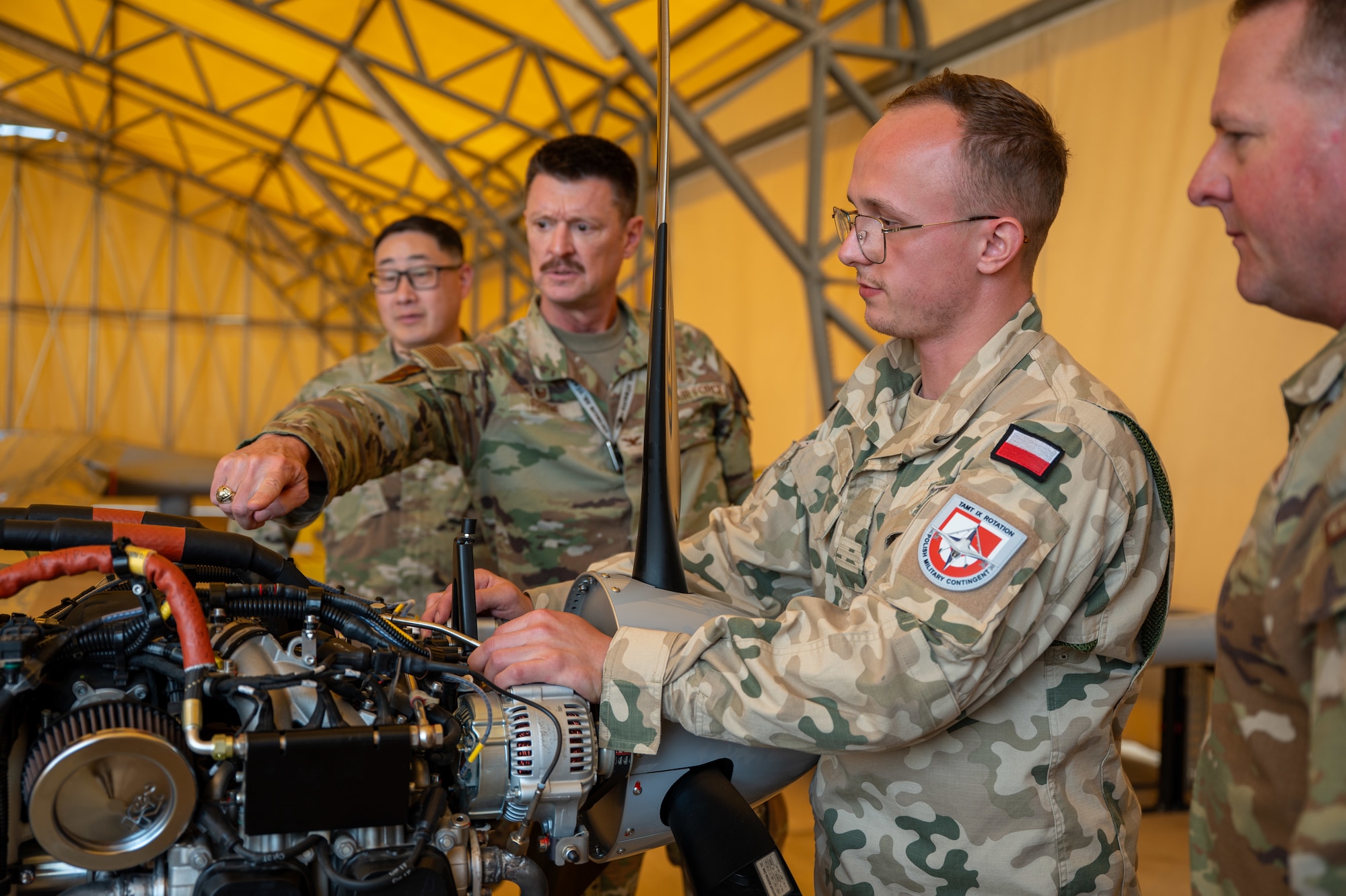 Service members pointing at a drone