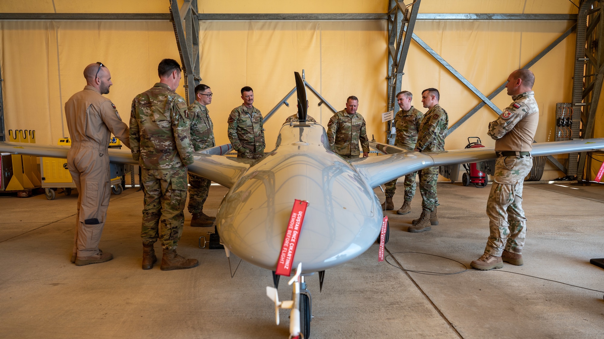 a group of service members viewing a drone