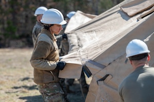 An airman builds a tent.