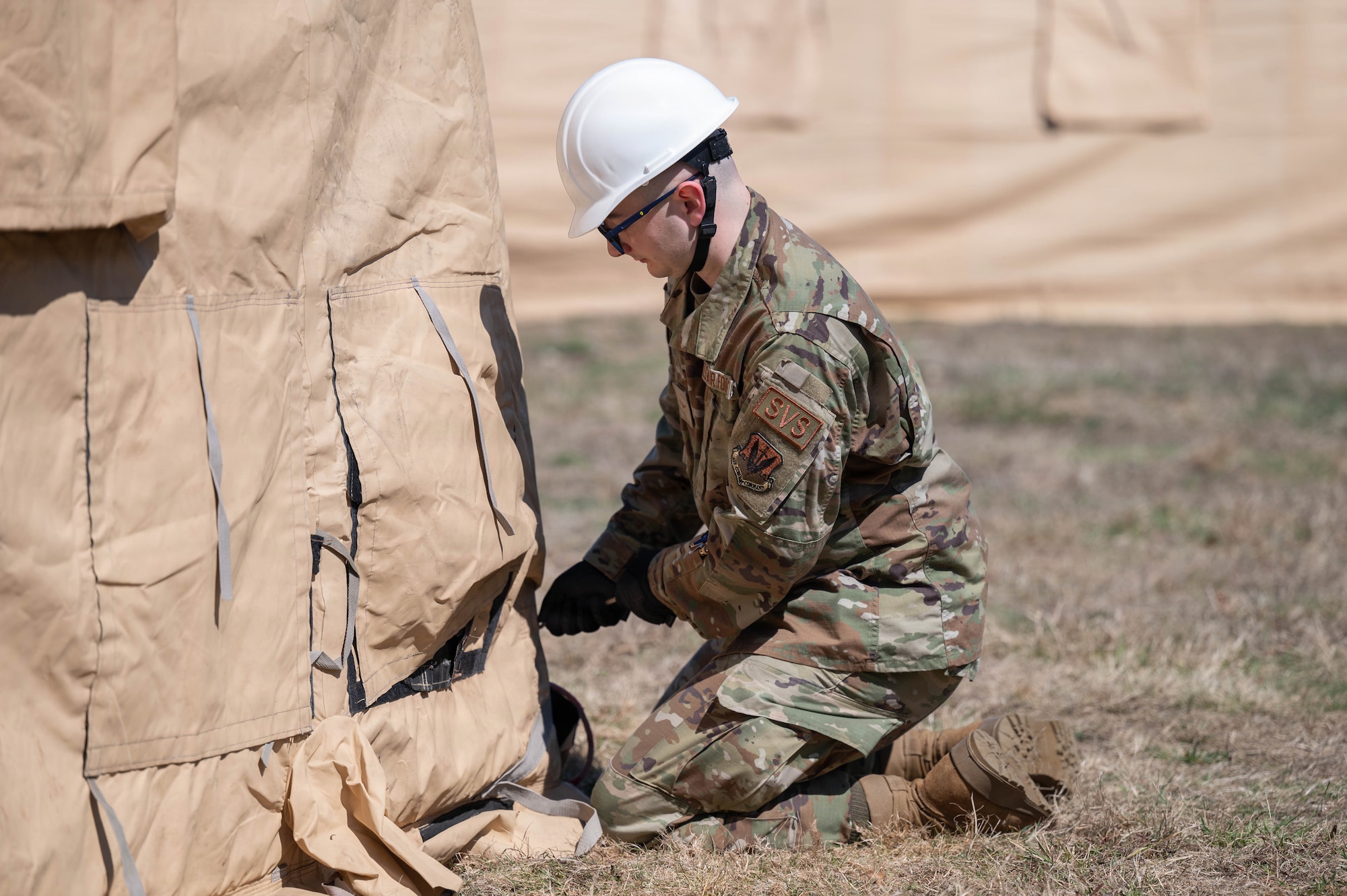 An airman builds a tent.