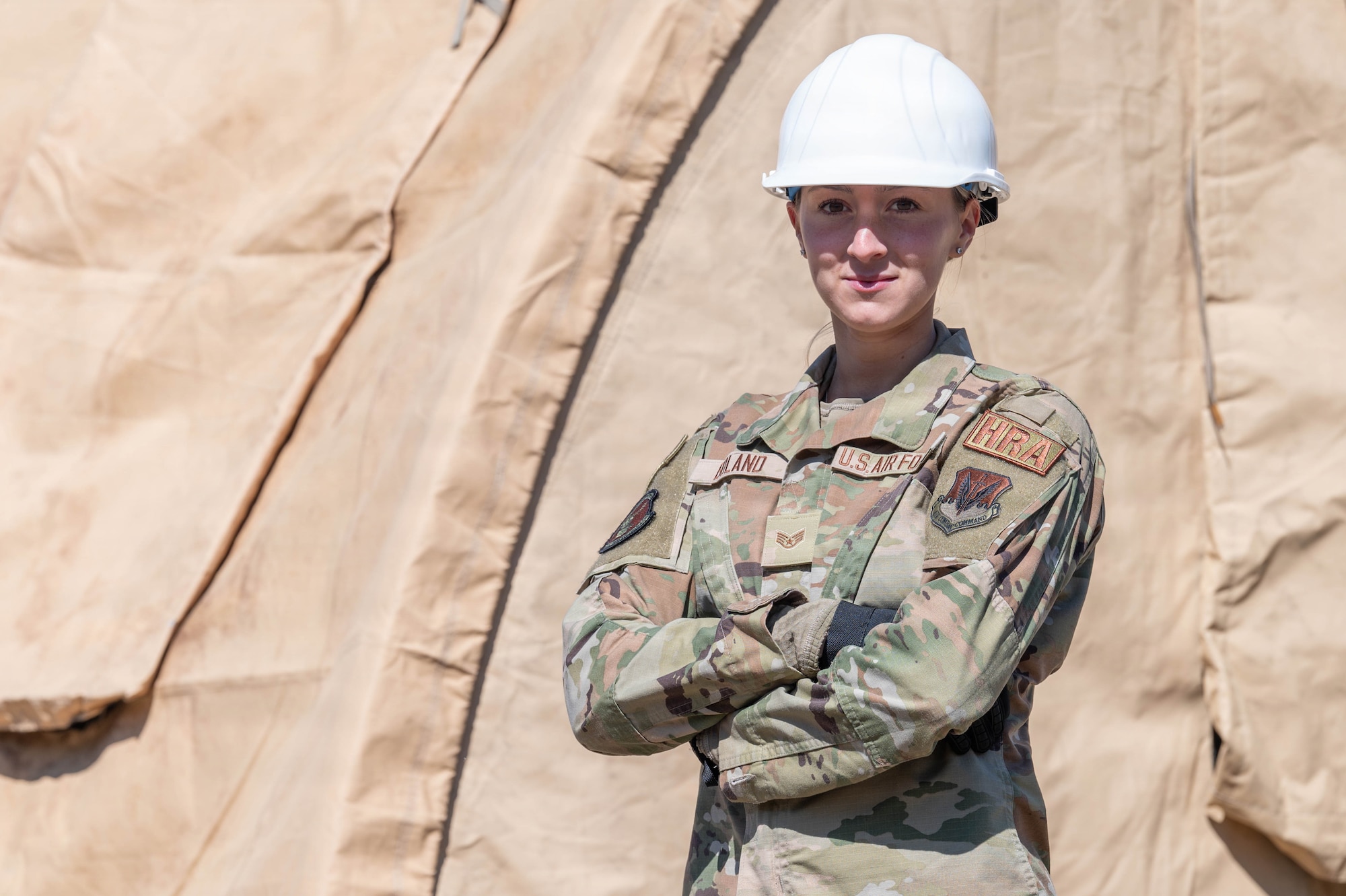 Airman stands in front of a tent.