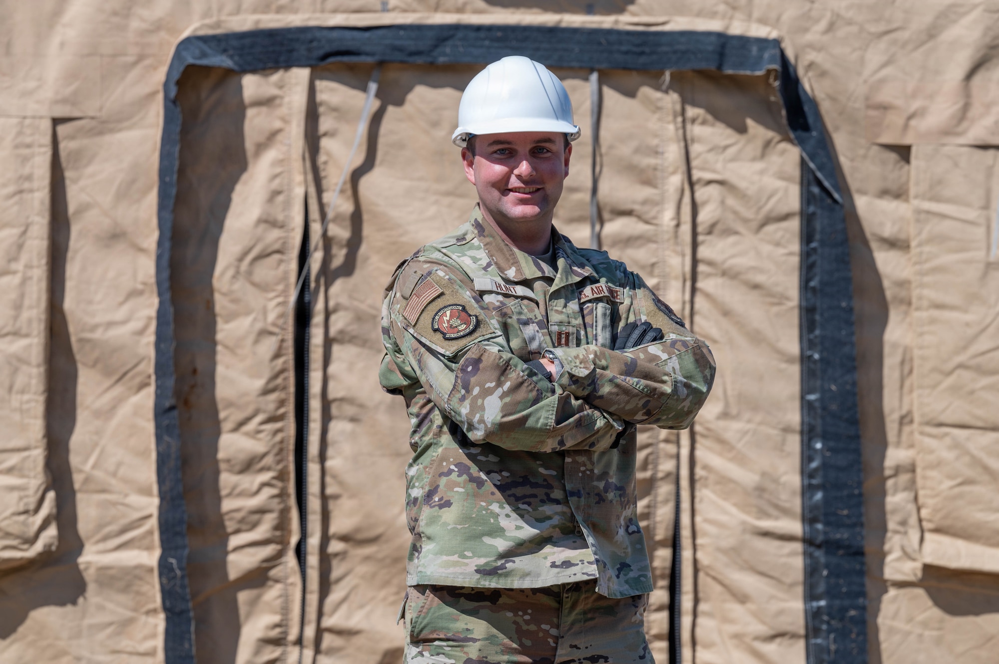 Airman stands in front of a tent.