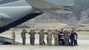 Airmen render honors as Soldiers assigned to the Montana Army National Guard Honor Guard conduct a dignified transfer.