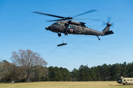 A UH-60 Black Hawk assigned to the Mississippi Army National Guard raises a medical litter carrying a medical practice dummy during exercise Sentry South 26-2 at Camp Shelby Joint Forces Training Center, Mississippi, March 2, 2026. Sentry South 26-2 is a large force employment exercise focused on major combat operations and joint maritime opportunities in a contested or degraded operational environment. Sentry South 26-2 applies joint and combined warfighting doctrine against realistic and robust enemy integrated threat systems, all while under safe and controlled conditions. (U.S. Air National Guard photo by Staff Sgt. Nicholas Swift)