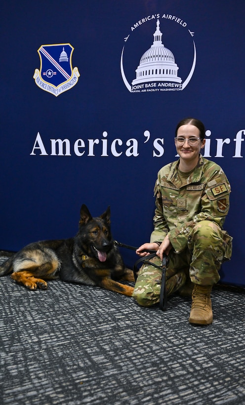 U.S. Air Force Senior Airman Daylynn Robinson, 316th Security Forces Support Squadron military working dog handler, celebrates with Military Working Dog Baily, assigned to the 316th SSPTS, during his retirement ceremony.