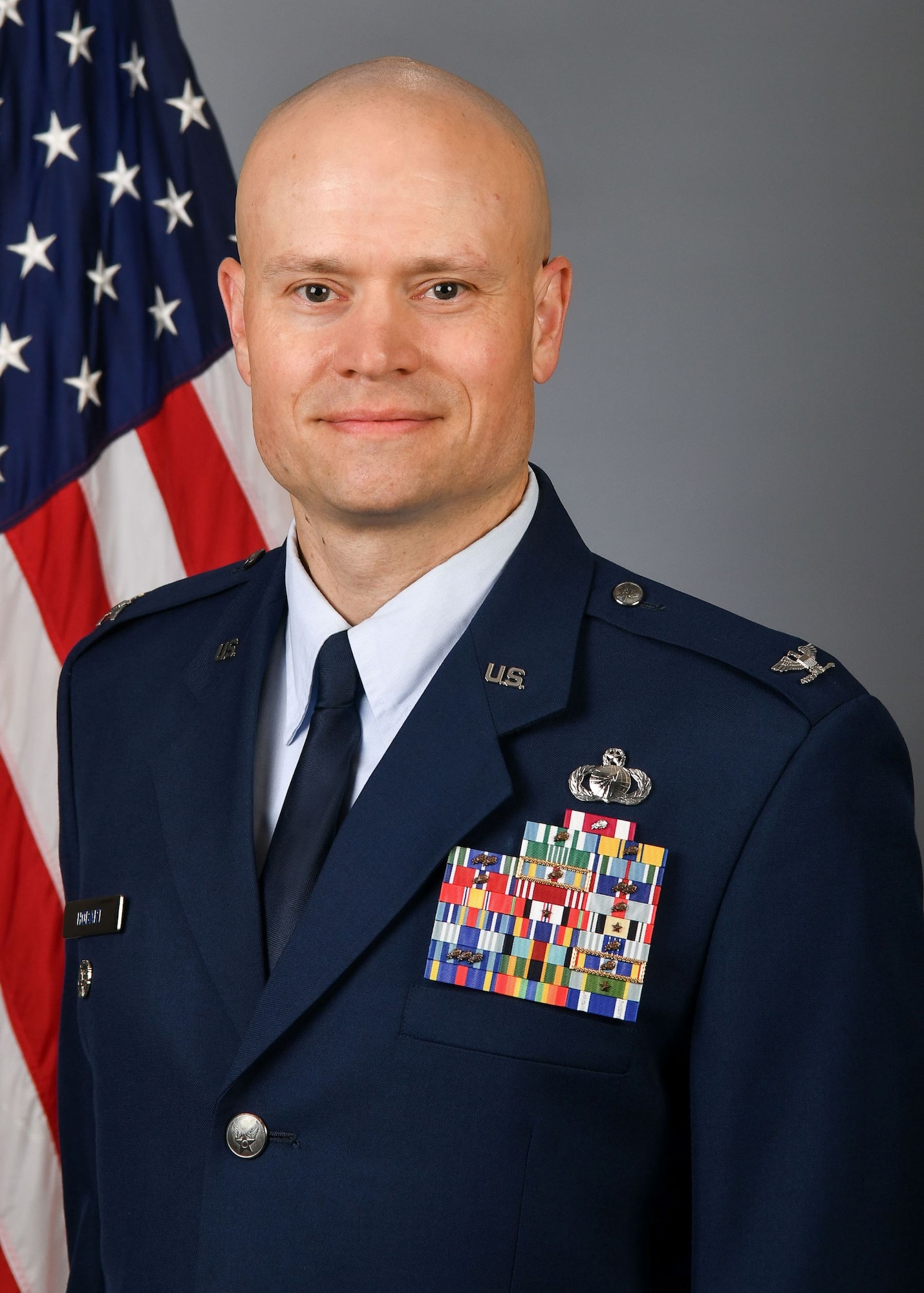 Man in dress uniform in front of flag