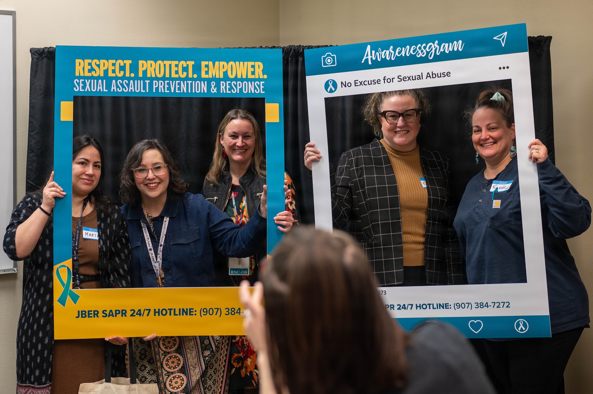 Guests at the 3rd Annual Sexual Assault Prevention and Response Open House take photos with props on Joint Base Elmendorf-Richardson, Alaska, April 2, 2026. The open house welcomed JBER civilians and military personnel across multiple agencies to connect, discuss and provide resources for one another, kicking off the month of April, also known as Sexual Assault Awareness and Prevention Month. (U.S. Air Force photo by Airman 1st Class Eli Rose)