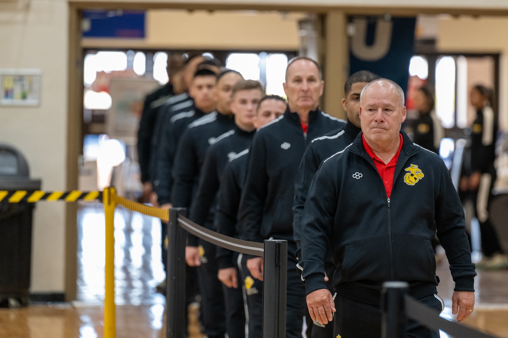 Marine Corps Wrestling Coach Rob Hermann leads the Marines down the mat during opening ceremonies, as Service members participate in the Armed Forces Sports Men’s and Women’s Wrestling Championships at the Mitchell W. Stout Physical Fitness Center on Fort Bliss, Texas, March 14, 2026. Service members compete in Greco-Roman and freestyle wrestling for championship honors while representing their respective services.
