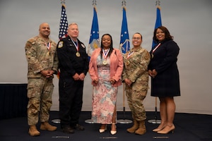 From left: U.S. Air Force Master Sgt. Michael Hooper, first sergeant with the 11th Civil Engineer Squadron; Sgt. 1st Class Robert Cox, operations flight chief with the 11th Security Forces Squadron; Cheryl Grant, security assistant for reports and analysis with the 11th SFS; Master Sgt. Devin Garcia, financial management flight chief with the 11th Comptroller Squadron; and Welth Cooper, commodities and services flight chief with the 11th Contracting Squadron, gather during the Air Force District of Washington annual award ceremony at Joint Base Anacostia-Bolling, Washington, D.C., April 9, 2026. The event honored outstanding performance and achievements across AFDW. (U.S. Air Force photo by Airman 1st Class Arlene Carrara)