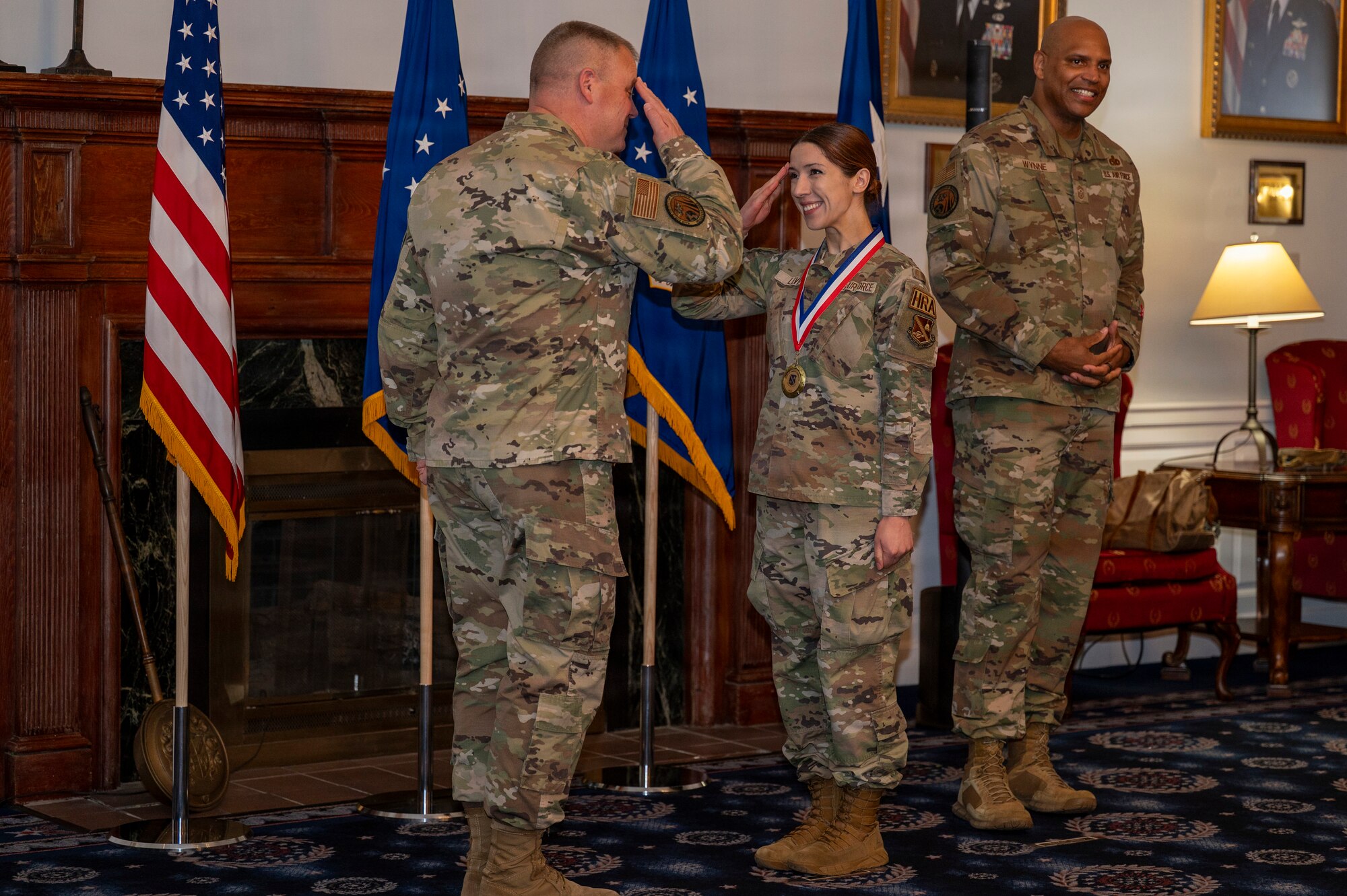 U.S. Air Force Airman 1st Class Sanda Levey, center, administrative apprentice with the 11th Comptroller Squadron, salutes Maj. Gen. Daniel A. DeVoe, Air Force District of Washington and 320th Air Expeditionary Wing commander, at the AFDW annual awards ceremony on Joint Base Anacostia-Bolling, Washington, D.C., April 9, 2026. The ceremony highlighted members across AFDW for their mission accomplishments throughout the year. (U.S. Air Force photo by Senior Airman Shanel Toussaint)