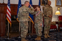 U.S. Air Force Airman 1st Class Sanda Levey, center, administrative apprentice with the 11th Comptroller Squadron, salutes Maj. Gen. Daniel A. DeVoe, Air Force District of Washington and 320th Air Expeditionary Wing commander, at the AFDW annual awards ceremony on Joint Base Anacostia-Bolling, Washington, D.C., April 9, 2026. The ceremony highlighted members across AFDW for their mission accomplishments throughout the year. (U.S. Air Force photo by Senior Airman Shanel Toussaint)