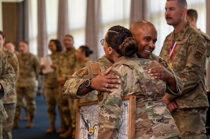 U.S. Air Force Chief Master Sgt. Anthony Thompson Jr., center, senior enlisted leader for Joint Base Anacostia-Bolling and the 11th Wing command chief, congratulates Master Sgt. Devin Garcia, a flight chief with the 11th Comptroller Squadron, during the Air Force District of Washington annual awards ceremony on JBAB, Washington, D.C., April 9, 2026.  The ceremony highlighted members across the AFDW for their mission accomplishments throughout the year. (U.S. Air Force photo by Senior Airman Shanel Toussaint)
