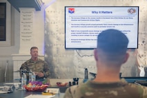 A photo of a man giving a presentation to base leadership.