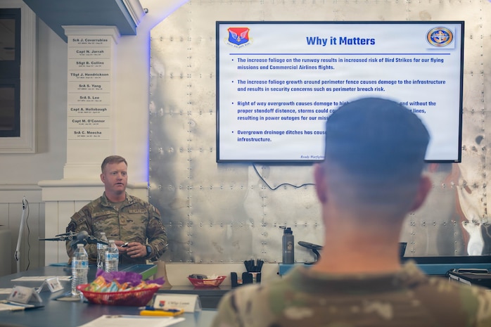 A photo of a man giving a presentation to base leadership.