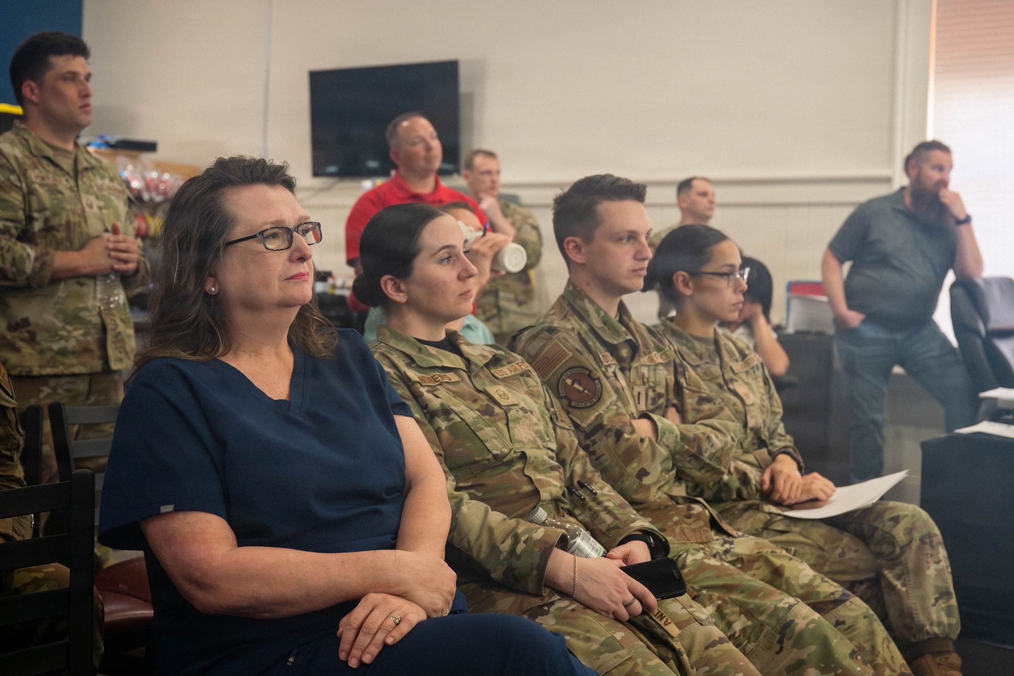 A photo of civilian workers and Airmen listening to a presentation.