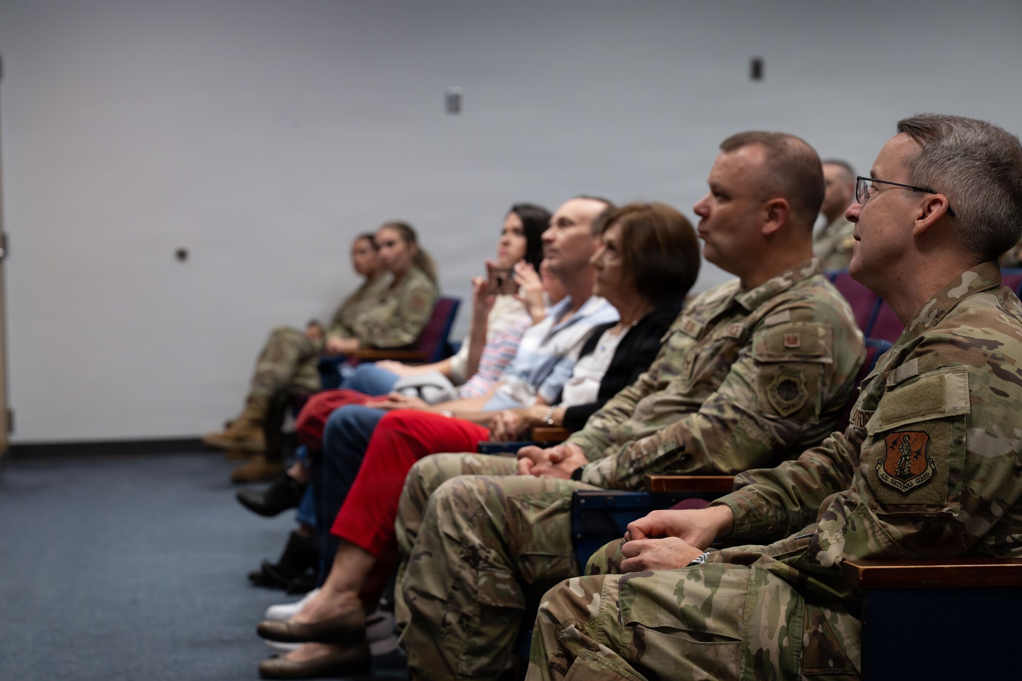 Leadership from the West Virginia Air Guard and family in attendance listen attentively as (Retired) Colonel William D. Peters Jr. speaks during his induction into the Hall of Honor at the 130th Airlift Wing Headquarters building in Charleston, W. Va. on April 11, 2026. Audience members are drawn in as Peters tells stories of his extensive service. (U.S. Air National Guard photo by Tech. Sgt. Kelvin McConnell)