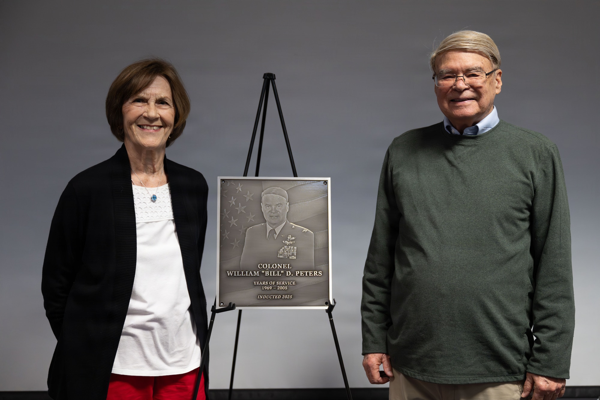 (Retired) U.S. Air National Guard Colonel William D. Peters Jr. (right), stands beside his wife, Sharon Peters, for a photo after his induction into the Hall of Honor at the 130th Airlift Wing Headquarters building in Charleston, W. Va. on April 11, 2026. Peters is the third inductee into the Hall of Honor which celebrates former members of the unit that gave exceptional service and left a resounding impact. (U.S. Air National Guard photo by Tech. Sgt. Kelvin McConnell)