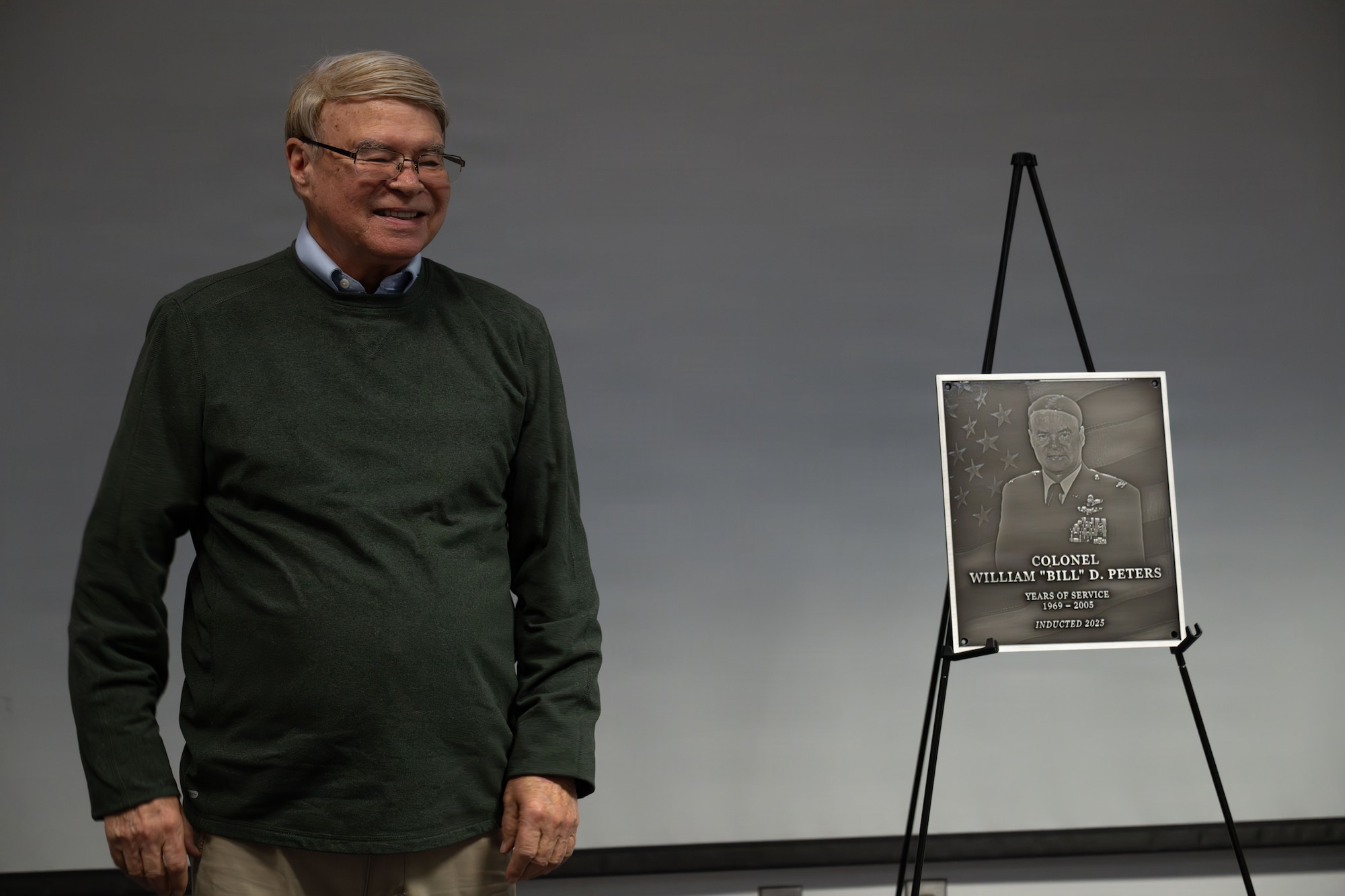 (Retired) U.S. Air National Guard Colonel William D. Peters Jr. stands proud after his induction into the Hall of Honor at the 130th Airlift Wing Headquarters building in Charleston, W. Va. on April 11, 2026. Peters was inducted for his exemplary service and advancement to state aviation, spanning over three decades in length. (U.S. Air National Guard photo by Tech. Sgt. Kelvin McConnell)