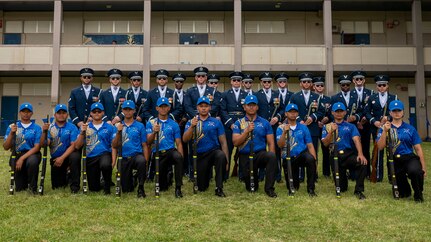 Airmen and JROTC cadets pose for a group photo in blue uniforms.