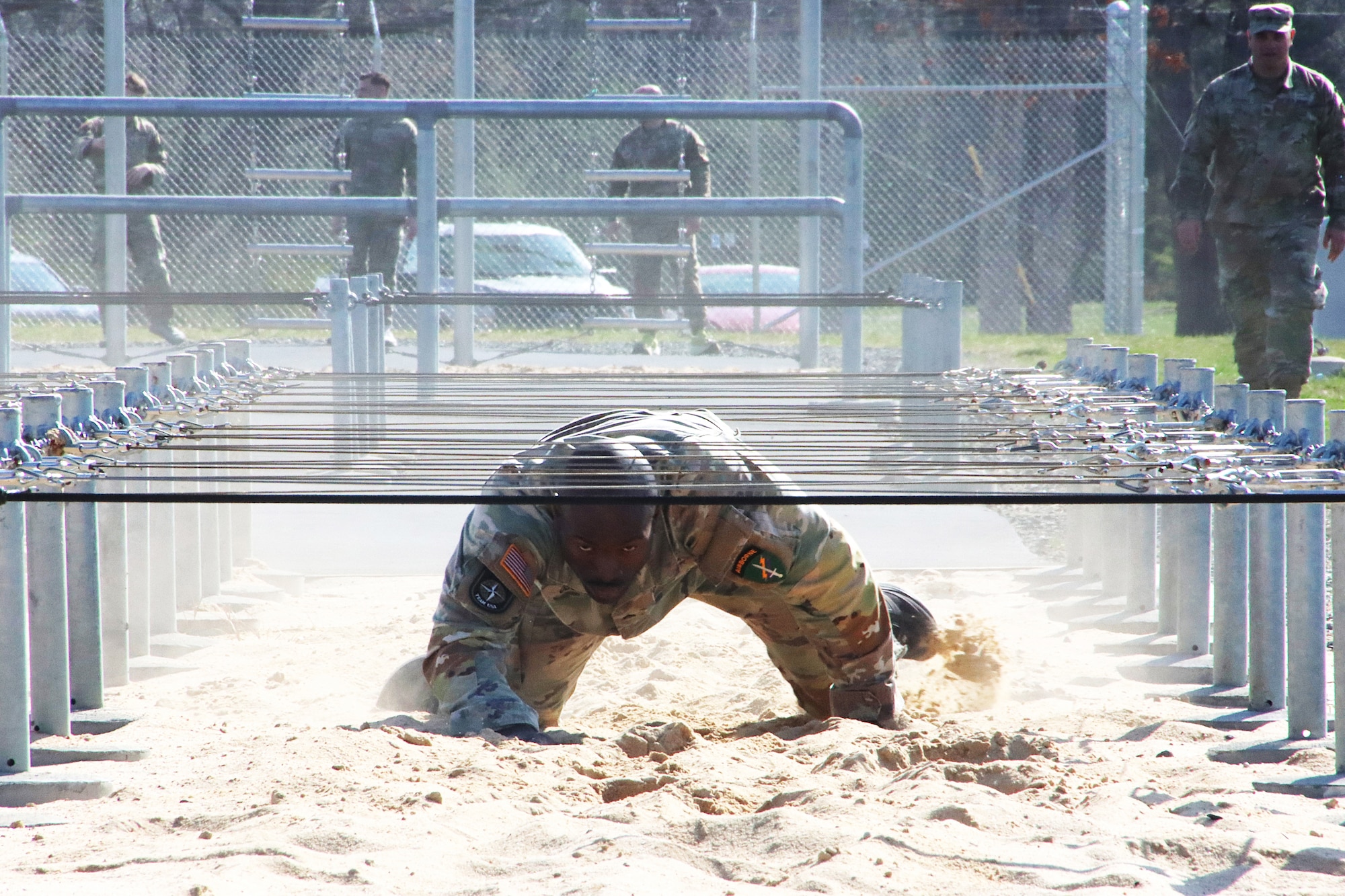 U.S. Army Reserve Staff Sgt. Cathier Ossiri, technical engineer, Alpha Company, 416th Civil Affairs Battalion (Airborne), low-crawls under wire on the NATO obstacle course during the U.S. Army Reserve Command’s Interallied Confederation of Reserve Officers (CIOR) selection competition at Joint Base McGuire-Dix-Lakehurst, N.J., April 1, 2026. Ossiri, who received the highest score in the competition, held March 30 - April 3, was among five NCOs and seven officers selected to represent the United States this summer in Europe at the 2026 CIOR Military Competition, where reserve forces from NATO nations will compete in challenges that test teamwork, endurance and combat skills. (U.S. Army photo by Steven Roussel)