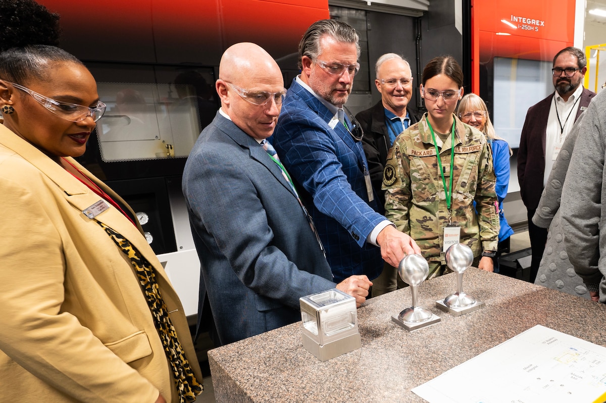 A group of professionals stand around a table and do a science experiment.