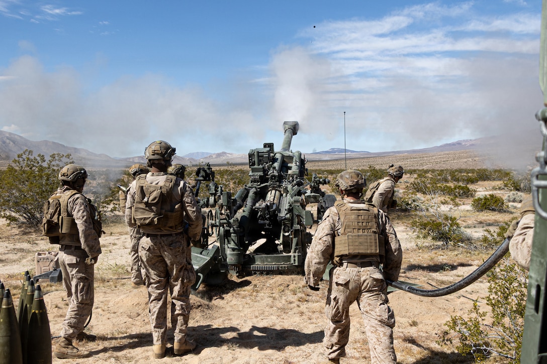 U.S. Marines with Kilo Battery, 3rd Battalion, 11th Marine Regiment, 1st Marine Division, fire a 155mm round from an M777A2 howitzer during a battery movement to contact exercise at Marine Corps Air Ground Combat Center, Twentynine Palms, California, March 6, 2026. The exercise allows Marines to conduct fire missions while continuously displacing to maintain the unit's survivability and culminating in the defense of the battery through direct fire engagements and crew-served weapons employment. (U.S. Marine Corps photo by Lance Cpl. Emilio Murphy)