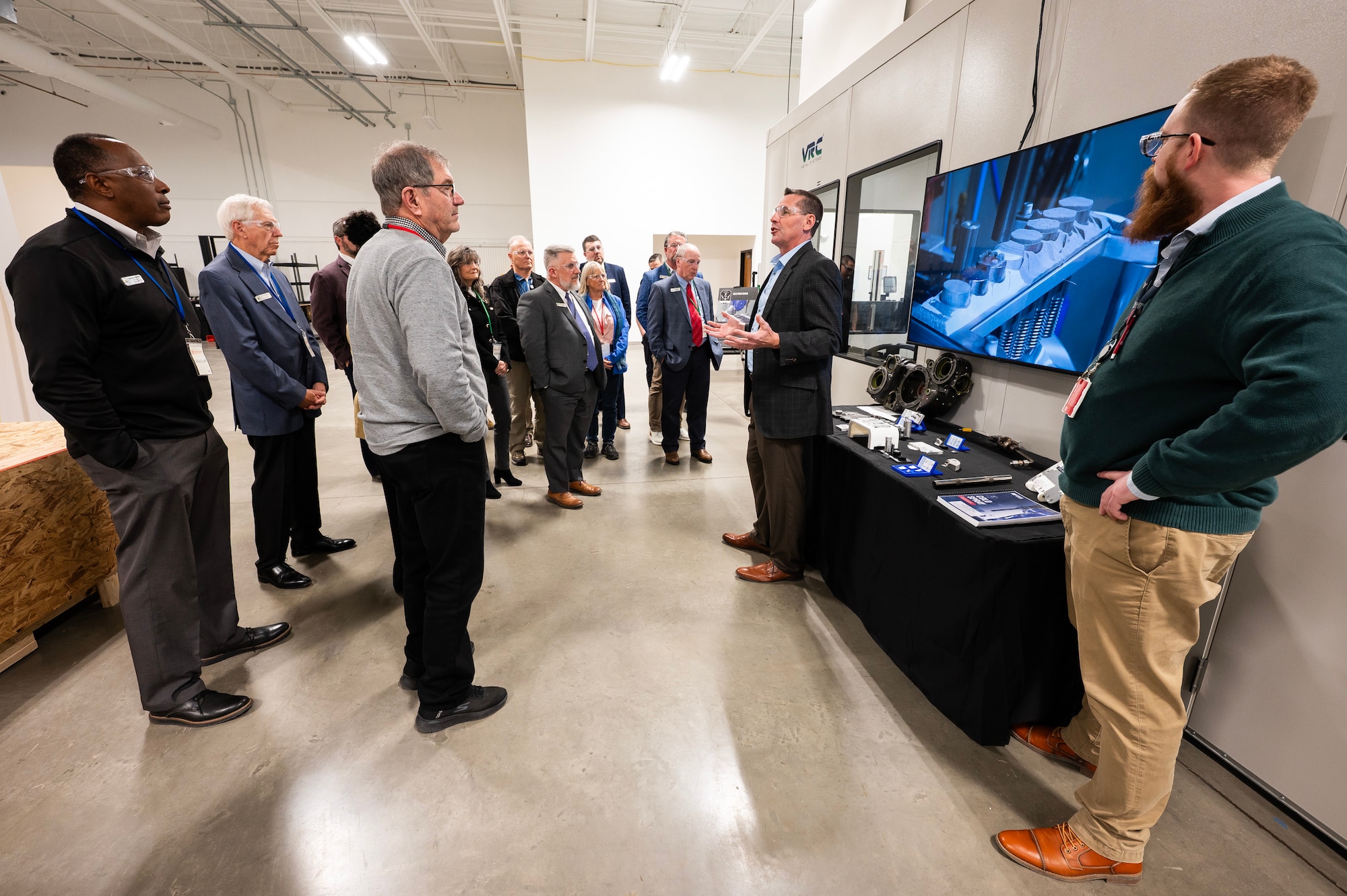 Group of professionals standing around TV screen.