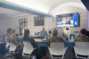 A photo of a man giving a presentation to base leadership.