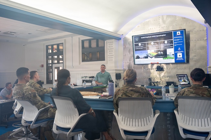 A photo of a man giving a presentation to base leadership.