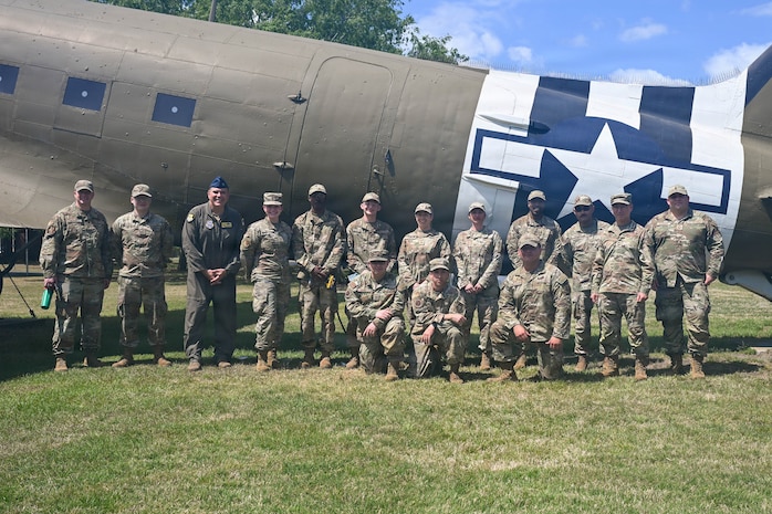 A photo of Airmen standing in front of a static C-47 Skytrain.
